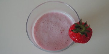 Festlig og farverig jordbærmilkshake med vaniljeis og mælk.