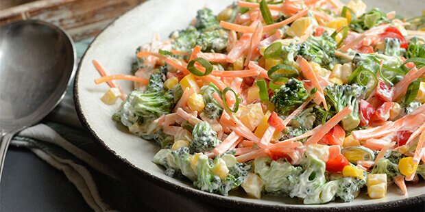Broccolisalaten er cremet og sprød med kombinationen af gulerødder, peberfrugt og majs.