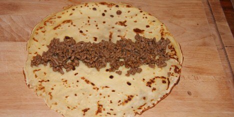 læg oksekød i en strimmel på midten af pandekagen