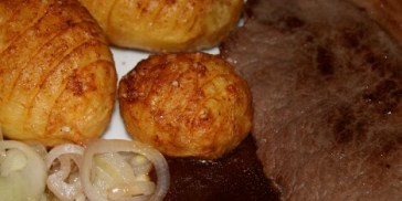 Engelsk bøf med brun sovs, bløde løg og hasselbagte kartofler.