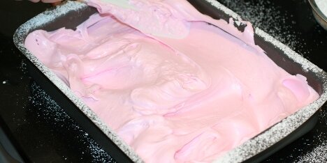 Blandingen fordeles i en form drysset med flormelis.