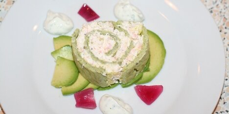 Her er rejerouladen serveren på en bund af avocadoskiver og med syltede rødløg som pynt.