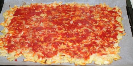 Den færdigbagte pizzabund med tomatpuré.