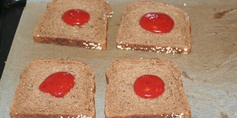 Brød smøres med tomat.