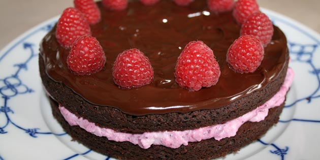 Pyntet med hindbær tager den færdige kage sig fantastisk ud.