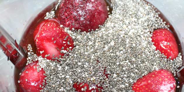 Chiafrø og frosne jordbær inden det blendes.