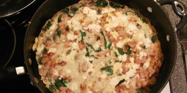 Den alsidige omelet med bacon og spinat toppes blødt med feta.