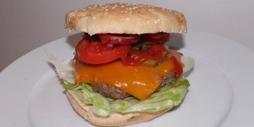 God udsigt: Farverigt grønt og smeltet cheddar titter frem fra cheeseburgeren.