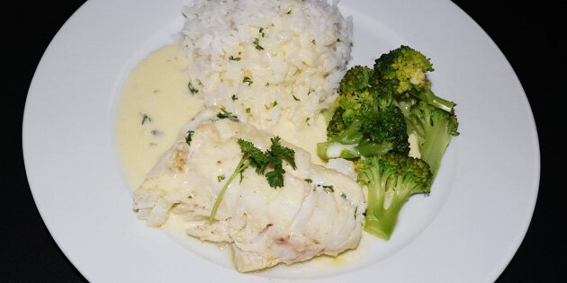 Broccolien tilføjer lidt farve til den stegte torsk med sovs.