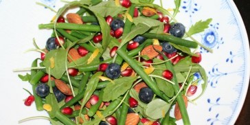 Grønne bønner, røde granatæblekerner, gul citronskal og blåbær giver en farverig salat.