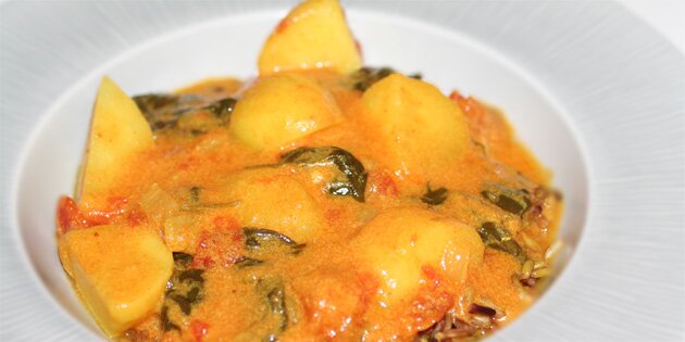 Kartoffelcurry serveret med brune ris.