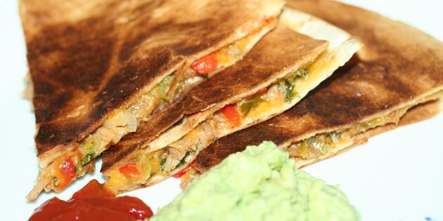 Serveres med guacamole og salsa som tilbehør.