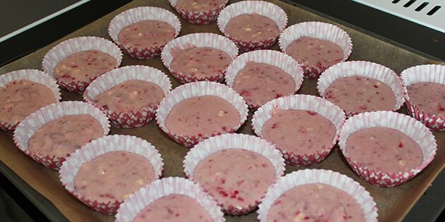 Her er den lyserøde dej kommet i muffinsformene.