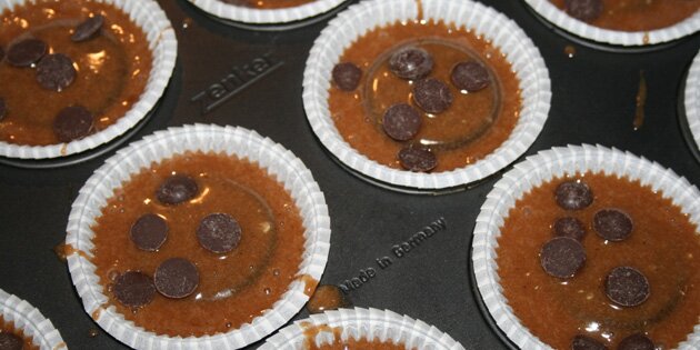 Her er dejen hældt i muffinsformene.