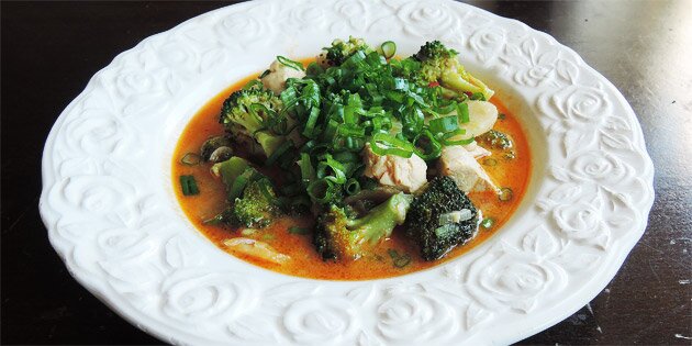 En portion karrysuppe med kylling og grøntsager