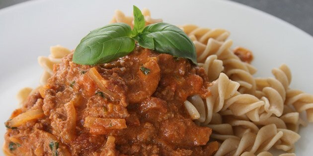 Her er kødsaucen serveret med pasta.