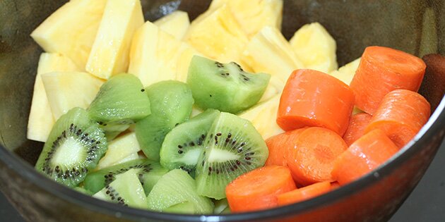 Ananas, kiwi og gulerødder skåret i mindre stykker.