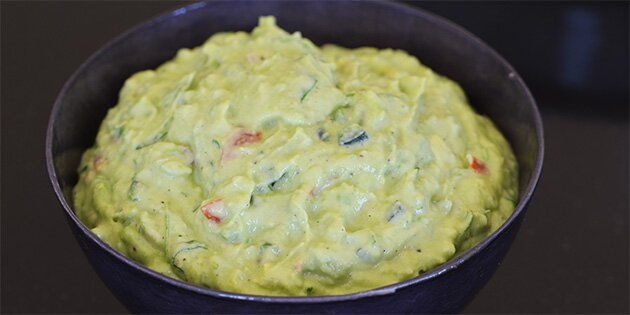 Man kan lige skimte tomat og jalapeños i den lysegrønne guacamole.