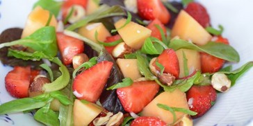 Røde jordbær og orange melon samt grøn salat og mynte.