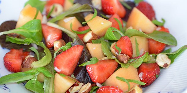 Røde jordbær og orange melon samt grøn salat og mynte.