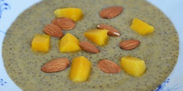 Den gulige chiagrød med mandler og frisk mango på toppen.