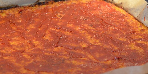 Tomatsaucen smøres på.