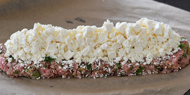 Den smuldrede feta fordeles henover farsbrødets bund.