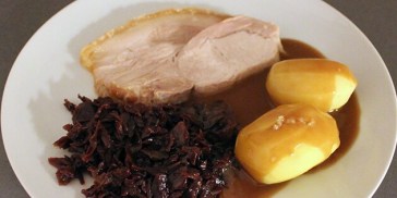 Saftig flæskesteg med kartofler, rødkål og brun sovs.