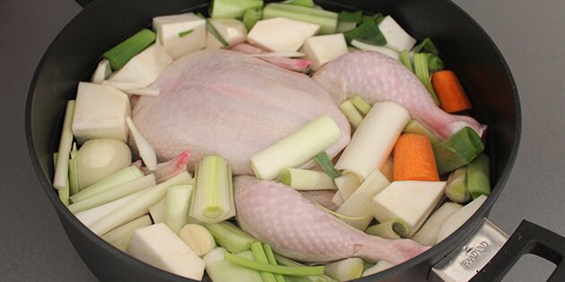 En hel kylling og grøntsager er klar til at koge 1 time.