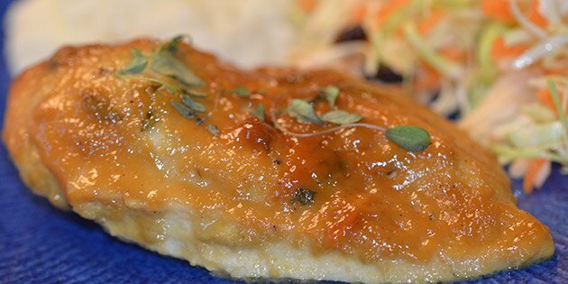 En kyllingefilet med forskellige grøntsager i baggrunden.