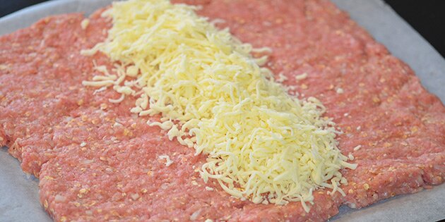 Farsen er spredt ud og osten er fordelt i midten