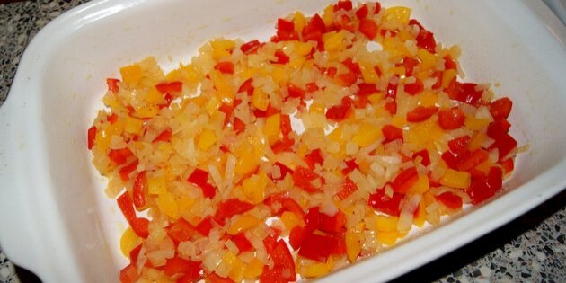 De svitsede løg og peberfrugt kommes op i et ildfast fad