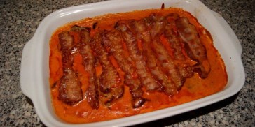 Den færdige ret med sprøde baconskiver på toppen.