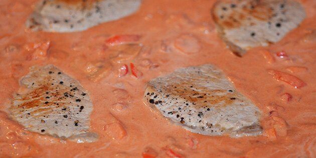 Koteletterne trykkes godt ned mellem grøntsagerne.