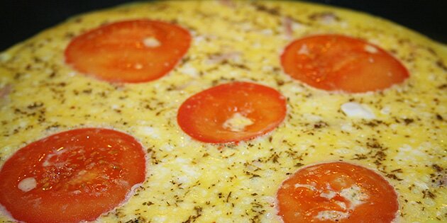 Friske tomatskiver på toppen af omeletten