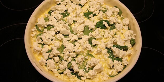 Laksetærten er klar til ovnen - med smuldret feta på toppen.