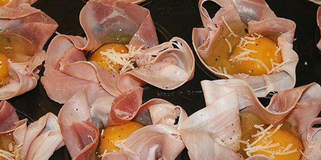 Skinken er på plads, og æggene er slået ud i muffinsformen