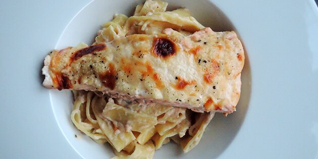 Den bagte laks kan serveres på en bund af frisk pasta med mornaysauce