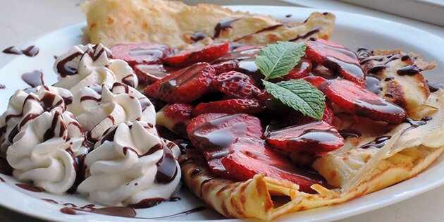 Skønne pandekager med lækker chokoladesovs, friske jordbær og flødeskum.