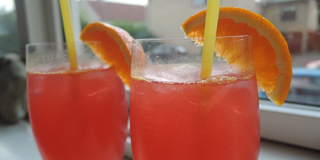 To lækre drinks med rød sodavand, vodka og appelsinjuice