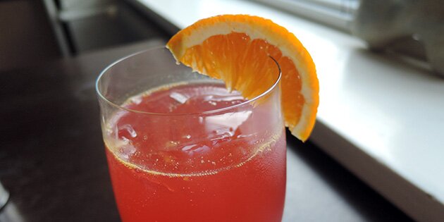 En filur drink med en skive appelsin på glasset