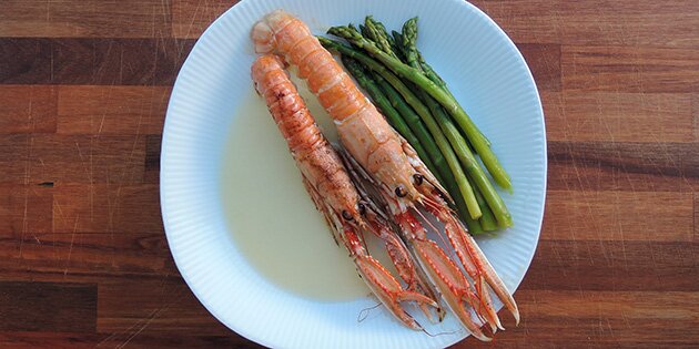 Jomfruhummerne serveres med dampede grønne asparges og en simpel hvidvinssauce