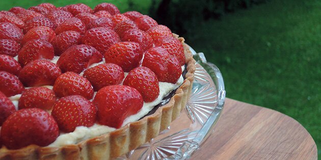 Den bløde flødecreme laves med hvid chokolade og husblas, der gør den fast i konsistensen under de mange jordbær