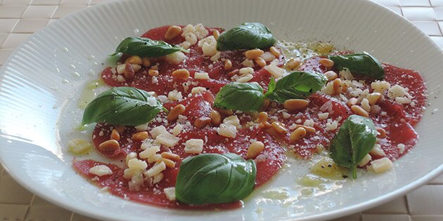 Lækker carpaccio med masser af frisk basilikum på toppen