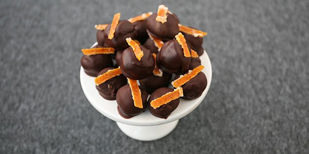 Konfektstykkerne overtrækkes med chokolade og pyntes med kandiseret appelsinskal