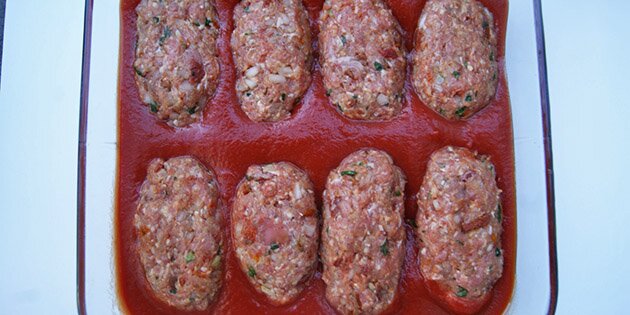 Her er farsbrødene formet og ligger klar i tomatsaucen.