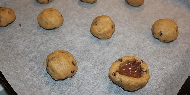 Nutellaen i midten af disse cookies giver en dejlig overraskelse, når man tager en bid. Luk dem lidt ligesom fastelavnsboller.