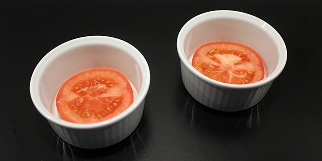 Læg en tomat i bunden af en skål, der kan tåle at komme i ovnen.