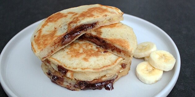 Suveræne amerikanske pandekager med fyld af Nutella og banan i skiver.