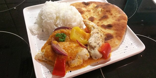 Server den dejlige omgang kylling i fad med f.eks. ris og naanbrød